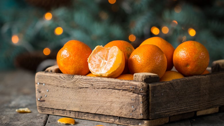  A collection of fresh mandarin oranges neatly gathered in a rustic wooden box